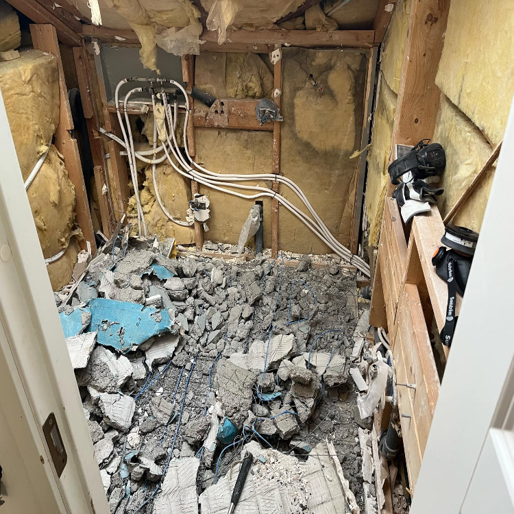 Pågående badrumsrenovering i Bromma där RR Syd förbereder för nya installationer. Bilden visar elrör och kabeldragning i vägg samt rivning av golv för kommande installation.