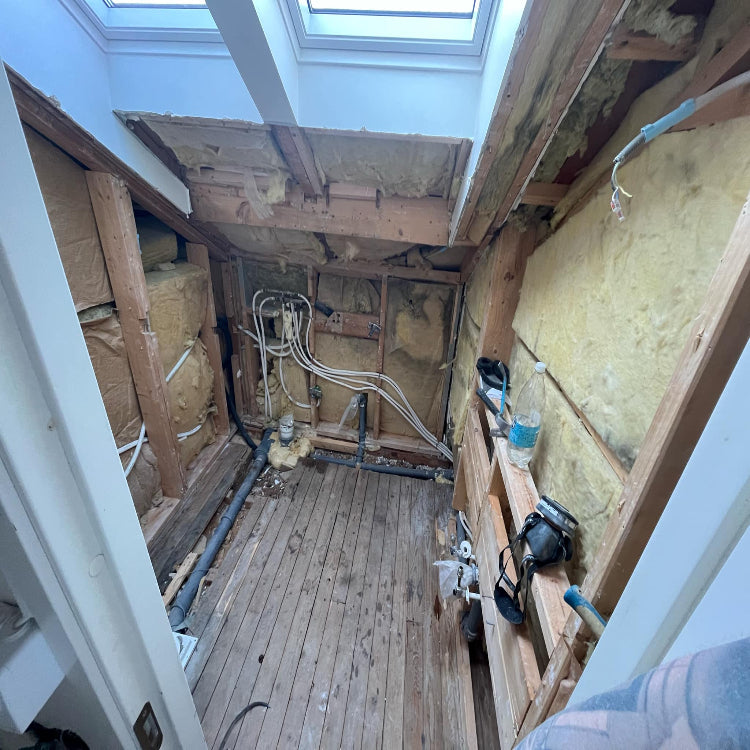 Pågående badrumsrenovering i Bromma där RR Syd utför rivning för att komma åt gamla rör och installationer. Exponerade väggar visar el- och rördragningar inför kommande installation.