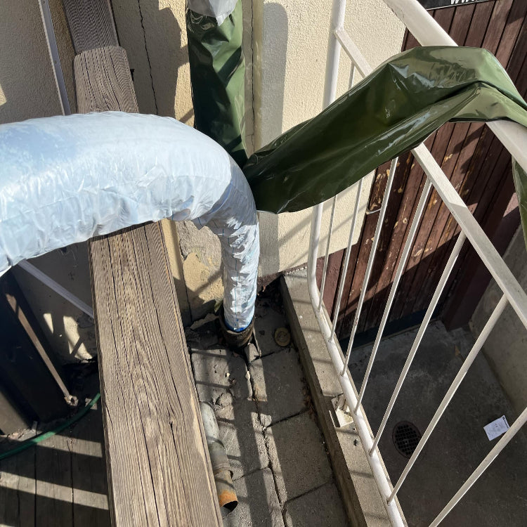Professionell relining av stående avloppsrör i Sundbyberg. Strumpinfodring med skyddsduk visar pågående renovering utan rivning.